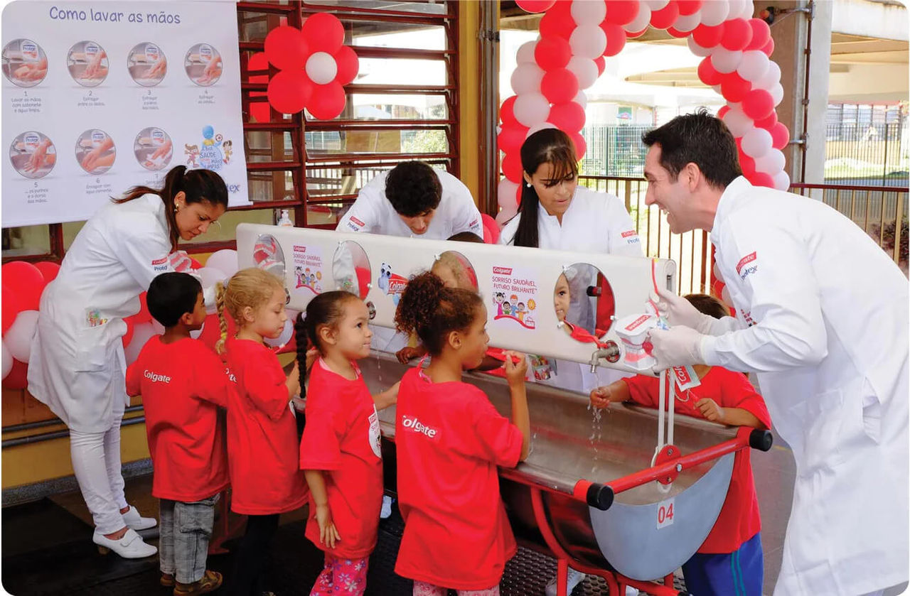 Dentistas y expertos en higiene bucal hablando con un grupo de niños como parte del evento «Sonrisas radiantes, futuros prometedores».